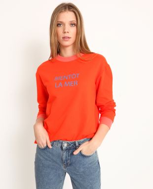 Sweat couleur grenadine.  - Col rond. - "Bientôt la mer" imprimé en bleu