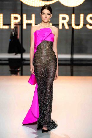 Black tulle gown embellished with multi-coloured tiffany paillettes and Swarovski crystals, featuring a fuchsia pink silk taffeta draped neckline and back frill.