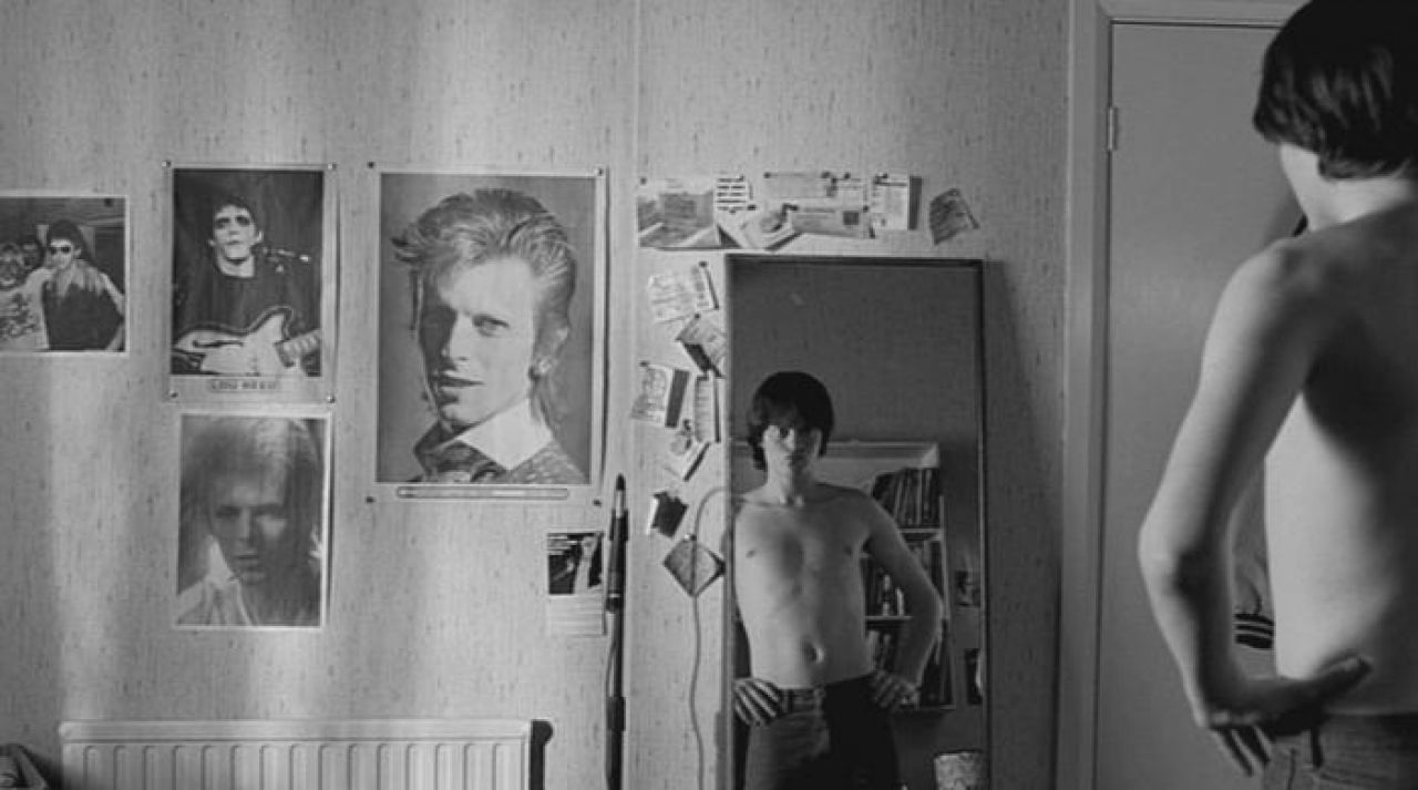 The portraits of David Bowie and Lou Reed, Ian Curtis (Sam Riley) in the Co...