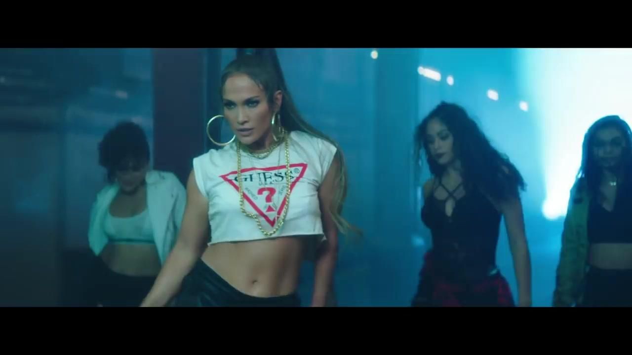 Le crop top Guess blanc de Jennifer Lopez dans le clip Amor, Amor, Amor (feat. Wisin)