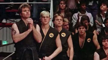 Le kimono noir Cobra Kai porté par Johnny (Wil­liam Zabka) dans la garde-robe du film Karaté Kid