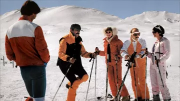 Les caches-oreilles en fourrure blanche de Gigi / Gisèle André (Marie-Anne Chazel) dans Les Bronzés font du ski