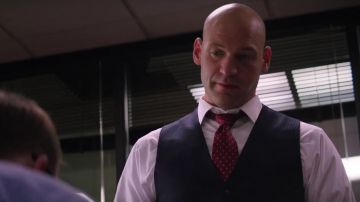 La corbata roja de Brian Woolf (Corey Stoll) en oro