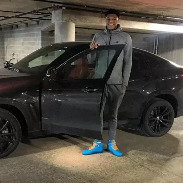 Sneakers blue high tops Nike Air Jordan 1 worn by Giannis Antetokounmpo in front of a car on a post to Instagram