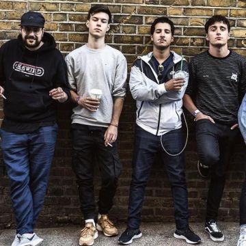 Sneakers black Vans Old Skool Hugo Dessioux aka Hugo All Alone posing in front of a brick wall on Instagram