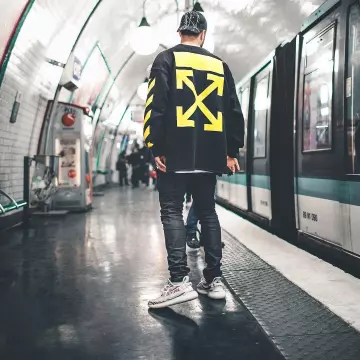 Les sneakers blanches imprimés zèbre Adidas Yeezy Boost 350 V2 "Zebra" de l'in­fluen­ceur Nik­las Woyt dans le métro sur Ins­ta­gram (@ez­cape)