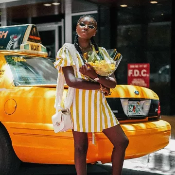 The striped dress of yellow and white worn by Jenny Florvil in front of a taxi on Instagram