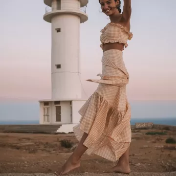 The skirt patterns vichy Marion Autran in front of a lighthouse on a post-Instagram
