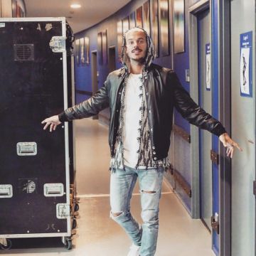 La veste bomber en cuir noir Givenchy avec étoiles porté par Matt Pokora en coulisses sur un post Instagram