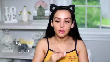 Le débardeur jaune "L'amour l'aventure et la vie" de Carli Bybel dans sa vidéo "Get ready with me : Travel day! ✈️"
