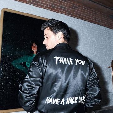 La chaqueta negra "Thank you Have a nice day" de Patrick Lim usada por Jack Falahee en instagram