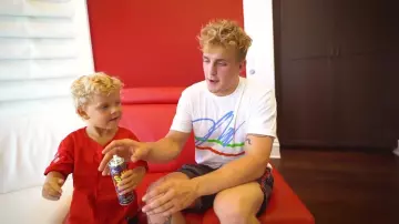 Le t-shirt blanc avec la signature de Jake Paul dans la vidéo YouTube MINI JAKE PAUL & ERIKA GO ON THEIR FIRST DATE!! (CUTE)