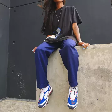 Le t-shirt noir Kaws X Uniqlo porté par Aude Julie assise sur un muret sur Instagram