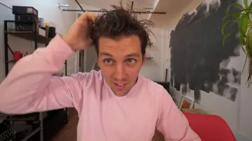 The sweater in pink worn by Peter Croce in his video "these people who have too much money"