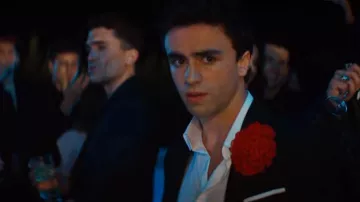 La boutonnière rouge en soie en forme de fleur de Samuel (Itzan Escamilla) dans Élite (S01E01)