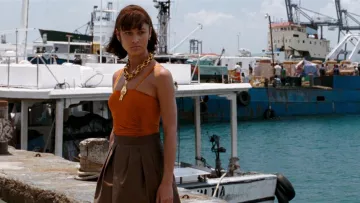 La tenue authentique (jupe marron & top orange) Jasper Conran de Camille Montes (Olga Kurylenko) dans Quantum of Solace