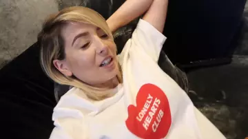 Zoe Sugg, también conocida como la camiseta blanca de Zoella con corazón rojo en su video "Monkeys, Mazes & Mini PJ Haul"