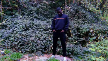 El suéter Negro Vision con el logotipo naranja usado por Dinos en su clip de Helsinki