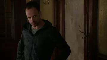 The sweatshirt hoody grey Uiqlo of Sherlock Holmes (Jonny Lee Miller) in Elementary S05E03