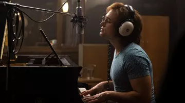 Camiseta azul estampada usada por Elton John (Taron Egerton) como se ve en Rocketman