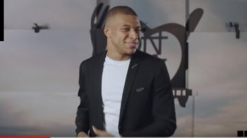 La placa de chaqueta de lana Christian Dior Atelier de Kylian Mbappé en el clip oficial Les Enfoirés 2019