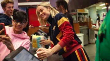 Captain Marvel Tracksuit worn by Brie Larson in Brie Lar­son Sur­prises Movie­go­ers in a Cap­tain Mar­vel Track­suit! YouTube Video