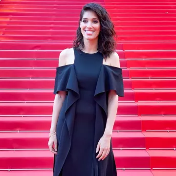 El vestido negro con los hombros desnudos usado por Laurie Cholewa en los escalones en la ceremonia de apertura del Festival de Cine de Cannes el 14 de mayo de 2019