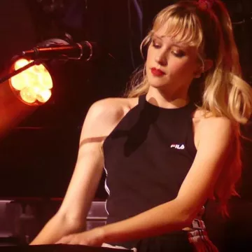 Le crop top noir ras de cou Fils Fila porté par Angèle sur scène lors de son concert le 23 mai 2019 au Summum sur sa tournée Brol des Zenith