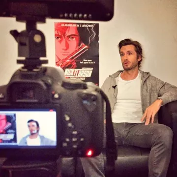 Le sweat zippé à capuche gris clair chiné porté par Philippe Lacheau pour parler de Nicky Larson Private Eyes diffusé au Grand Rex en juin 2019