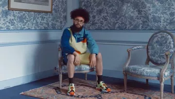 Le pullover multicolore Aimé Leon Dore porté par Kikesa dans son clip La paix