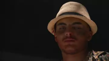 The hat in beige straw with black band of RK in her video clip Cataleya