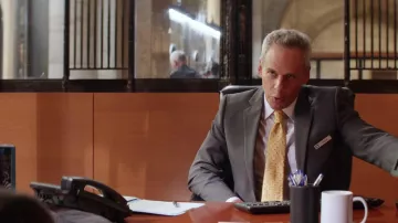 The yellow tie with polka dots worn by Chuck Lofton (Josh Pais) in Turning to the old