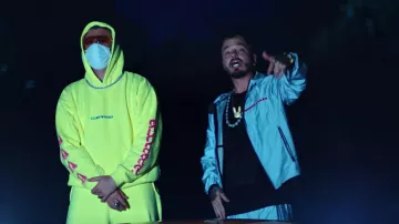 Prada gray reflective nylon windbreaker worn by Bad Bunny as seen in his QUE PRETENDES music video with J. Balvin