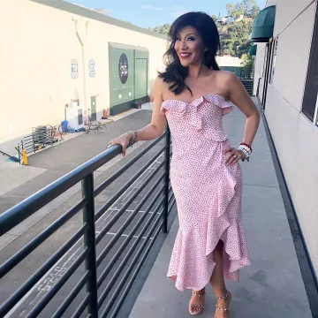 White long dress with red dots worn by Julie Chen behind the scenes of Big Brother tv show July 26, 2019