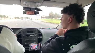 Le sweatshirt à capuche Champion à logos verts et inscription dans le dos porté par Prime dans sa vidéo YouTube INVITÉ PAR UN SHEIKH D'ABU DHABI ! #LAVIDE 145
