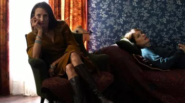 Les bottes hautes noires portées par la psy de Mélanie (Camille Cottin) dans Deux moi