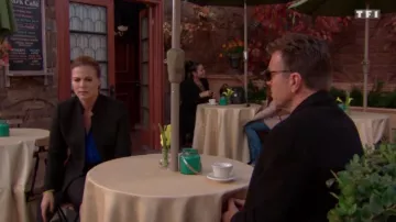 The long coat cinched with black scope by (Elizabeth Hendrickson) in the fires of love in the episode of 16 September on TF1