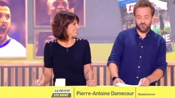 Suéter negro de Estelle Denis con manga corta y joyas en los hombros en L'Équipe d'Estelle el 16.09.2019
