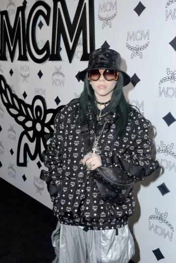 The jacket printed MCM Worldwide worn by Billie Eilish at the opening of the MCM Global Flagship Store on Rodeo Drive in Los Angeles in march 2019