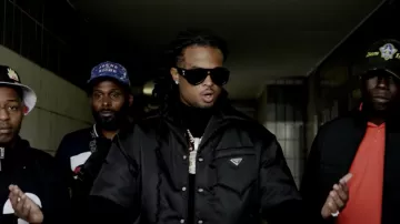 The padded jacket black Prada worn by Kalash in her video clip Salam