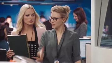 Le chemisier gris foncé porté par une productrice (Kate McKinnon) dans Scandale