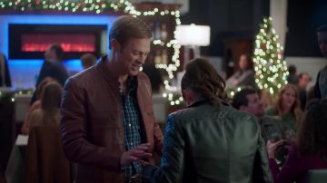 Chaqueta de motocicleta de cuero marrón usada por Everett (George Stults) en la puesta en escena de navidad