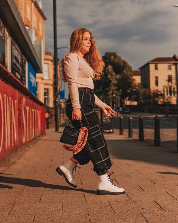Botas blancas de encaje de Yasmin Thompson en la cuenta de Instagram @asliceofchic