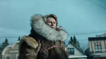 Long Faux Fur Coat Hood­ie worn by Leonhard Seppala (Willem Dafoe) in Togo