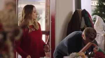 Le pull rouge de Claire (Alexandra Breckenridge) dans Le livre de Noël