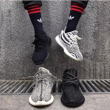 El par de zapatillas Adidas Yeezy Boost 350v2 Zebra y el par de adidas Yeezy Triple Black Reflective en @basedofhype