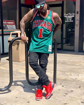 Les sneakers rouges avec imprimé portées par Wale sur le compte Instagram de @wale