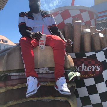 Les sneakers air jordan blanches et rouges avec imprimé portées par Rick Ross sur le compte Instagram de @richforever