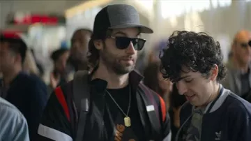 Chaqueta negra de Henderson (Chris D'Elia) en YOU (S02E02)