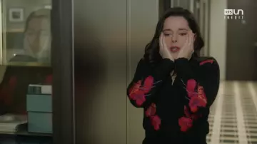 The black sweater with red flowers of Noémie Leclerc (Laure Calamy) in Ten Percent S03E02
